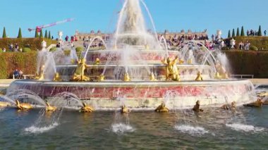 Versailles Sarayı 'ndaki süslü bir çeşmede yaldızlı heykellerin ve akan suyun ayrıntılı manzarası. Versailles, Fransa - 12 Ekim 2025.