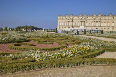 Turistler ve klasik peyzaj ile çevrili Versailles Sarayı 'nın bahçelerinde su püskürten çeşmenin geniş panoramik manzarası. Versailles, Fransa - 12 Ekim 2025.