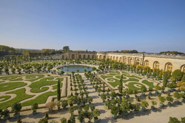 Fransa 'daki Versailles Sarayı' nda ağaçlı, patikalı ve göletli simetrik bahçeler. Klasik Avrupa peyzaj mimarisi ve kraliyet mirası. Versailles, Fransa - 12 Ekim 2025.