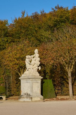 Versailles bahçesinde sonbahar ağaçlı klasik mermer heykel. Versailles, Fransa - 12 Ekim 2025.