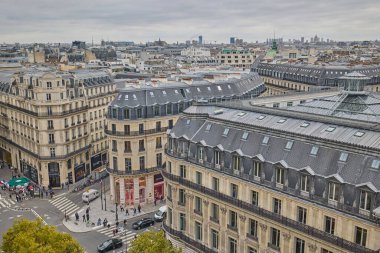 Opera bölgesi yakınlarındaki Paris çatıları ve Haussmann binalarının manzarası yüksek. Sokakları ve yayaları aşağıda olan klasik Avrupa şehir manzarası. Paris, Fransa - 13 Ekim 2025.