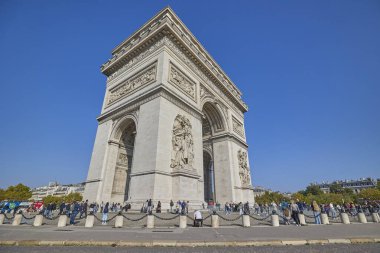Paris 'te turistlerin açık mavi gökyüzü altında olduğu Zafer Takı anıtı. Paris, Fransa - 12 Ekim 2025.