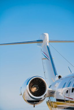 Kuyruk yüzgeci, uçak gövdesi ve jet motoru mavi gökyüzüne karşı küçük bir iş jeti..