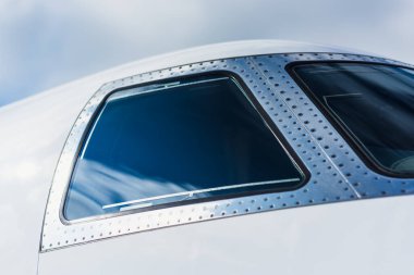 Bir Gulfstream 260 'ın sağ kokpit penceresinin yakın çekimi, perçinlenmiş metal çerçeve, renkli cam ve yumuşak doğal ışık altında pürüzsüz gövdeyi gösteriyor..