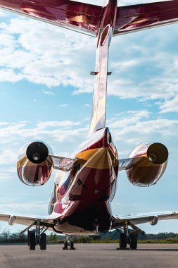 İkiz jet motorları, uzun iniş takımları ve dikey dengeleyicileri gösteren özel bir jetin arka görüntüsü. Güneşli bir günde mavi gökyüzü, iş seyahati, havacılık tasarımı veya lüks ulaşım için ideal..