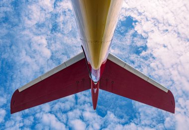 Bir iş jetindeki kuyruk ve yatay dengeleyicinin düşük açılı görüntüsü. Yapının alt kısmı bulutlarla dolu bir gökyüzüne karşı merkezli bir V şekli oluşturuyor..