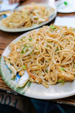 Bir tabak Amerikan Çin yemeği, sebzeli erişte ve tavuk.