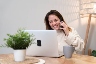 Ev düzeninden, iş yönetiminden ve iş görüşmesinden keyif alan bir kadın.