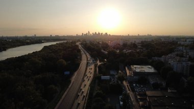 Yaz mevsiminde Varşova siluetine, Vistula Nehri 'ne, parklara, yeşil alanlara, konut bloklarına ve merkeze giden yoğun bir otoyola doğru pürüzsüz bir drone atışı. Doğu Avrupa ile ilgili belgeseller, seyahat videoları, reklamlar ve sinema projeleri için mükemmel..