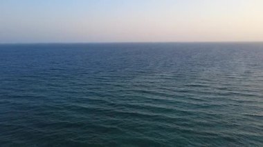 Turkuaz deniz suyu ve sahil bölgesi olan kayalık bir sahil şeridinin hava aracı görüntüleri. Berrak suları, doğal uçurumları ve deniz manzarası olan manzaralı yaz seyahatleri. Turizm, tatil ve doğa kavramları için ideal.