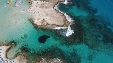 Turkuaz deniz suyu ve sahil bölgesi olan kayalık bir sahil şeridinin hava aracı görüntüleri. Berrak suları, doğal uçurumları ve deniz manzarası olan manzaralı yaz seyahatleri. Turizm, tatil ve doğa kavramları için ideal.
