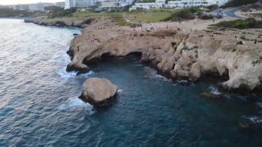 Turkuaz deniz suyu ve sahil bölgesi olan kayalık bir sahil şeridinin hava aracı görüntüleri. Berrak suları, doğal uçurumları ve deniz manzarası olan manzaralı yaz seyahatleri. Turizm, tatil ve doğa kavramları için ideal.