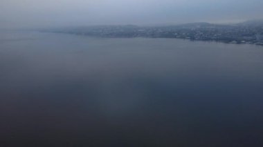 Bir İsviçre sabahının dinginliğini bu kasvetli Zürih havası ile yaşayın. Video, gölün gri, sisli atmosferini ve şehir sınırını yakalar. Hikaye anlatma, sinematik geçişler ya da melankolik kentsel görseller için mükemmel bir arka plan