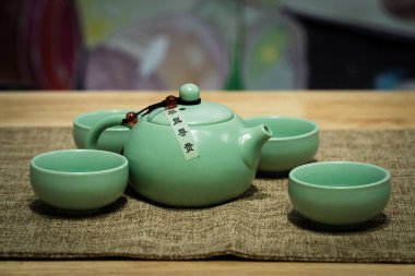 Yeşim yeşil çaydanlık masanın üzerindeki bez pedin üzerinde..