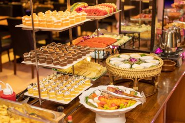 Kekler, şekerler ve meyveler açık büfe servisi için masanın üstünde düzenlenir..