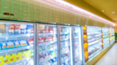 Ticari içecekler serinletici sırada çeşitli soğuk içecekler soyut bulanık arkaplanı gösteriyor. Süpermarket koridoru ve raflar bulanık arka plan. Marketin perakende satış konsepti. Yan Görünüm.