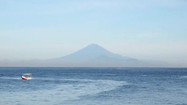 Eski Ampenan Limanı Senggigi plajından güzel bir okyanus manzarası denizin ortasında geleneksel bir balıkçı teknesi ve arka plan olarak aktif volkan Agung Bali Dağı manzarası..