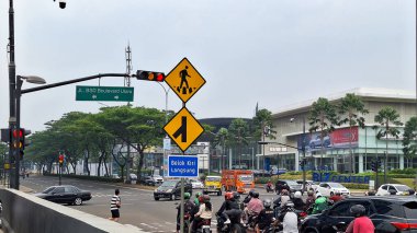 Tangerang Endonezya - 17 Ekim 2024: Yol kavşağındaki yol tabelası veya Rambu Lalu Lintas sola dön ve yaya geçidi için imza at.