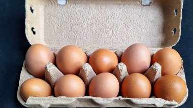 Açık kutuda taze organik tavuk yumurtası ya da siyah arka planda yumurta kabı. 10 'luk set, üst görünüm.
