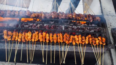 Satay (veya sate), bir adam tarafından mangal kömürü üzerinde kızartılan ve ete belirgin dumanlı bir tat veren, baharatlı, bambu çubuğunda şişlenmiş, popüler bir Güneydoğu Asya yemeği. Üst Görünüm.
