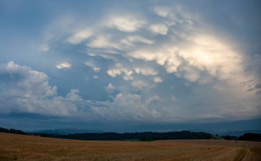 Gökyüzü biçilmiş bir tarlanın üzerinde bulutlarla