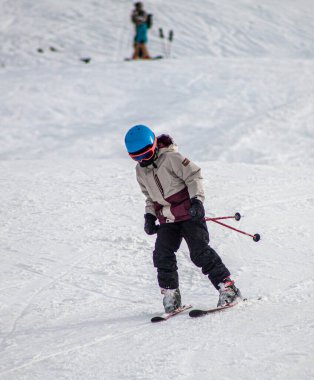 Karlı bir yamaçta genç bir kayakçı