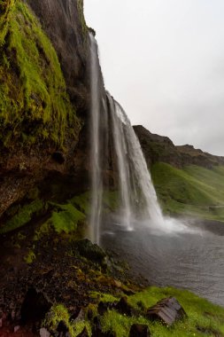 Seljalandsfoss Şelaleleri gri bir yaz gününde Seljalands Nehri 'ne akıyor, Güney İzlanda, İzlanda