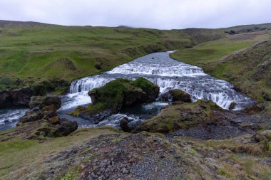 Skogafoss Şelaleleri 'nin en tepedeki manzarası Gri huysuz bir yaz gününde Skoga Nehri' ne akar, Güney İzlanda, İzlanda