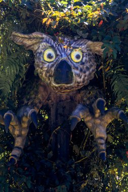 Kaprisli Ejderha Heykeli Geniş Sarı Gözlü Çalılar arasından Sunny Garden 'a bakıyor