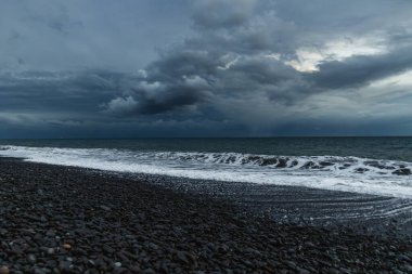 Kara Bulutlar, Yuvarlanan Dalgalar ve Huysuz Mavi Işıklı Madeira Okyanusu kıyısında dramatik bir fırtına..