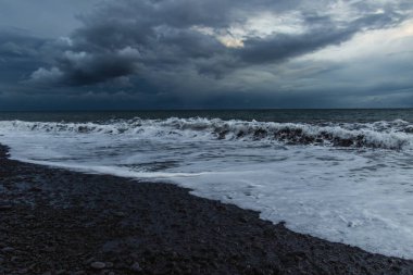 Kara Bulutlar, Yuvarlanan Dalgalar ve Huysuz Mavi Işıklı Madeira Okyanusu kıyısında dramatik bir fırtına..