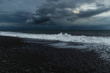 Kara Bulutlar, Yuvarlanan Dalgalar ve Huysuz Mavi Işıklı Madeira Okyanusu kıyısında dramatik bir fırtına..
