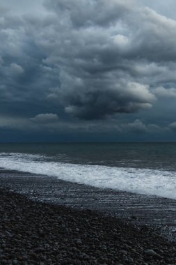 Kara Bulutlar, Yuvarlanan Dalgalar ve Huysuz Mavi Işıklı Madeira Okyanusu kıyısında dramatik bir fırtına..