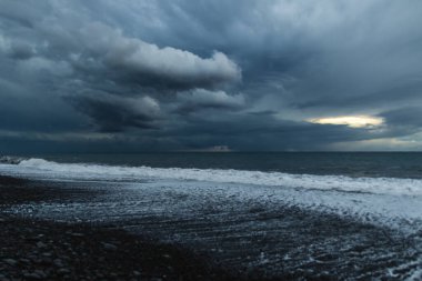 Kara Bulutlar, Yuvarlanan Dalgalar ve Huysuz Mavi Işıklı Madeira Okyanusu kıyısında dramatik bir fırtına..