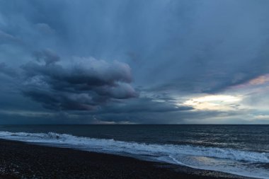 Kara Bulutlar, Yuvarlanan Dalgalar ve Huysuz Mavi Işıklı Madeira Okyanusu kıyısında dramatik bir fırtına..