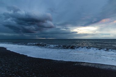 Kara Bulutlar, Yuvarlanan Dalgalar ve Huysuz Mavi Işıklı Madeira Okyanusu kıyısında dramatik bir fırtına..