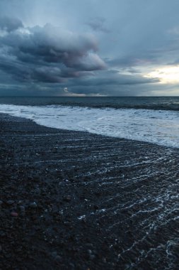 Kara Bulutlar, Yuvarlanan Dalgalar ve Huysuz Mavi Işıklı Madeira Okyanusu kıyısında dramatik bir fırtına..