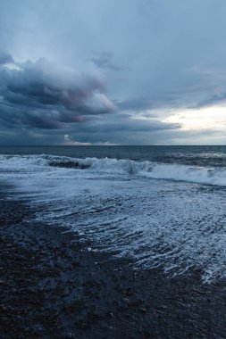 Kara Bulutlar, Yuvarlanan Dalgalar ve Huysuz Mavi Işıklı Madeira Okyanusu kıyısında dramatik bir fırtına..