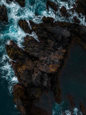 Güçlü Atlantik Okyanusu dalgalarının insansız hava aracı görüntüsü Portekiz 'in Madeira Adası' nın dramatik kıyı şeridi boyunca engebeli volkanik kayalara çarpıyor..