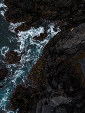 Güçlü Atlantik Okyanusu dalgalarının insansız hava aracı görüntüsü Portekiz 'in Madeira Adası' nın dramatik kıyı şeridi boyunca engebeli volkanik kayalara çarpıyor..