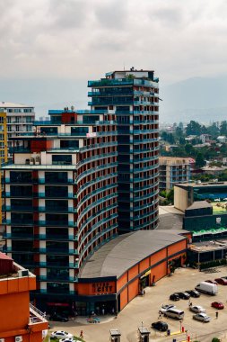 Gürcistan 'ın Batumi kentinde alışveriş merkezi ve inşaat vinçleriyle çağdaş cam cepheli ticari bina, Karadeniz kıyısındaki hızlı kentsel gelişimi vurguluyor..