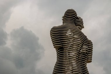 İkonik Ali ve Nino, gün batımında dramatik bulutlu gökyüzüne karşı duran Georgia, Batumi 'de hareket eden heykel. Modern dönüm noktası sonsuz aşkı ve birliği simgeliyor..