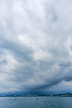Gürcistan 'ın batısındaki bir sahil kasabası üzerinde kara fırtına bulutları süzülüyor ve ufukta sisli dağlar görünüyor. Karamsar, dramatik atmosfer yalnızlığı, değişen havayı ve sinematik deniz manzarasını çağrıştırıyor..