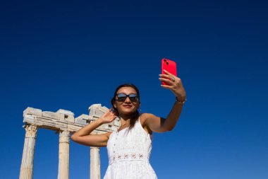 Beyaz Elbiseli Gülümseyen Kadın Eski Tapınak Harabelerinin önünde Selfie Çekiyor