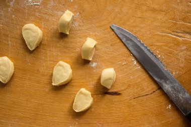 Çiğ Hamur Parçalarının Genel Görünümü ve Tahta Kesme Tahtasındaki Bıçak