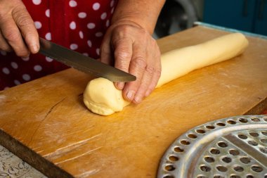 Eller, hamur işleri için çiğ hamur kesmek için bıçak kullanıyor.