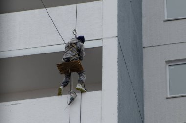 Endüstriyel Abseiler Sallanan Koltukla Yüksek Katlı Cephe 'de çalışıyor.
