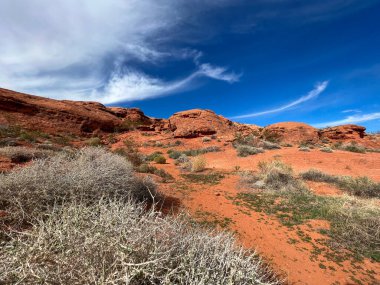 Kırmızı kumtaşı bulutları ve açık gökyüzü ile manzaralı çöl kanyonu manzarası Amerika 'daki engebeli araziyi gösteriyor doğal kaya oluşumları ve Amerika' nın güneybatısının geniş bir manzarası var.