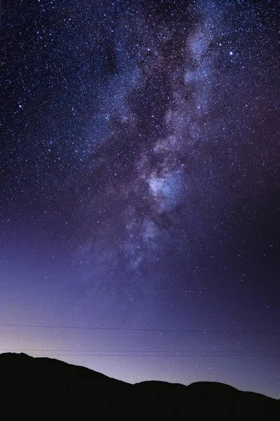 Alacakaranlıkta bir dağın üzerinde galaksiyle mavi yıldızlı bir gece, telefon dijital duvar kağıdı için 4k gradyan gökyüzü arkaplanı