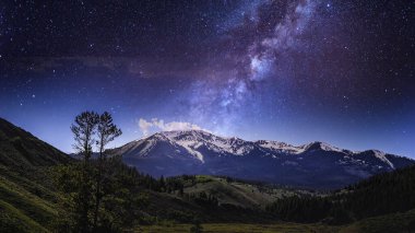 Mor galaksi ve yıldızlı bir gökyüzü alacakaranlıkta bir dağ manzarası, 4k evren manzara masaüstü arka planı veya pc duvar kağıdı